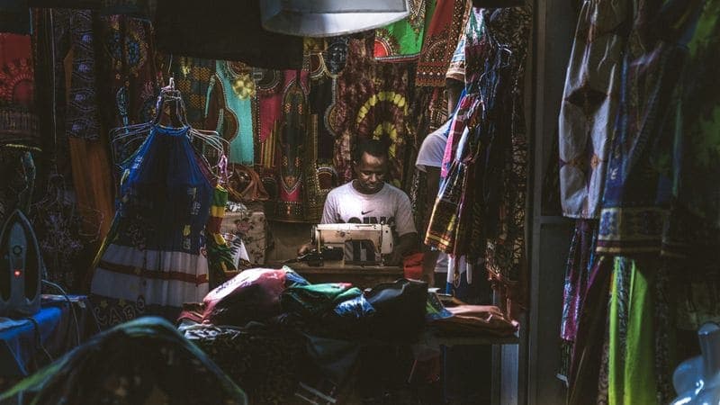 Commerçant rangeant ses produits en rayon dans sa boutique